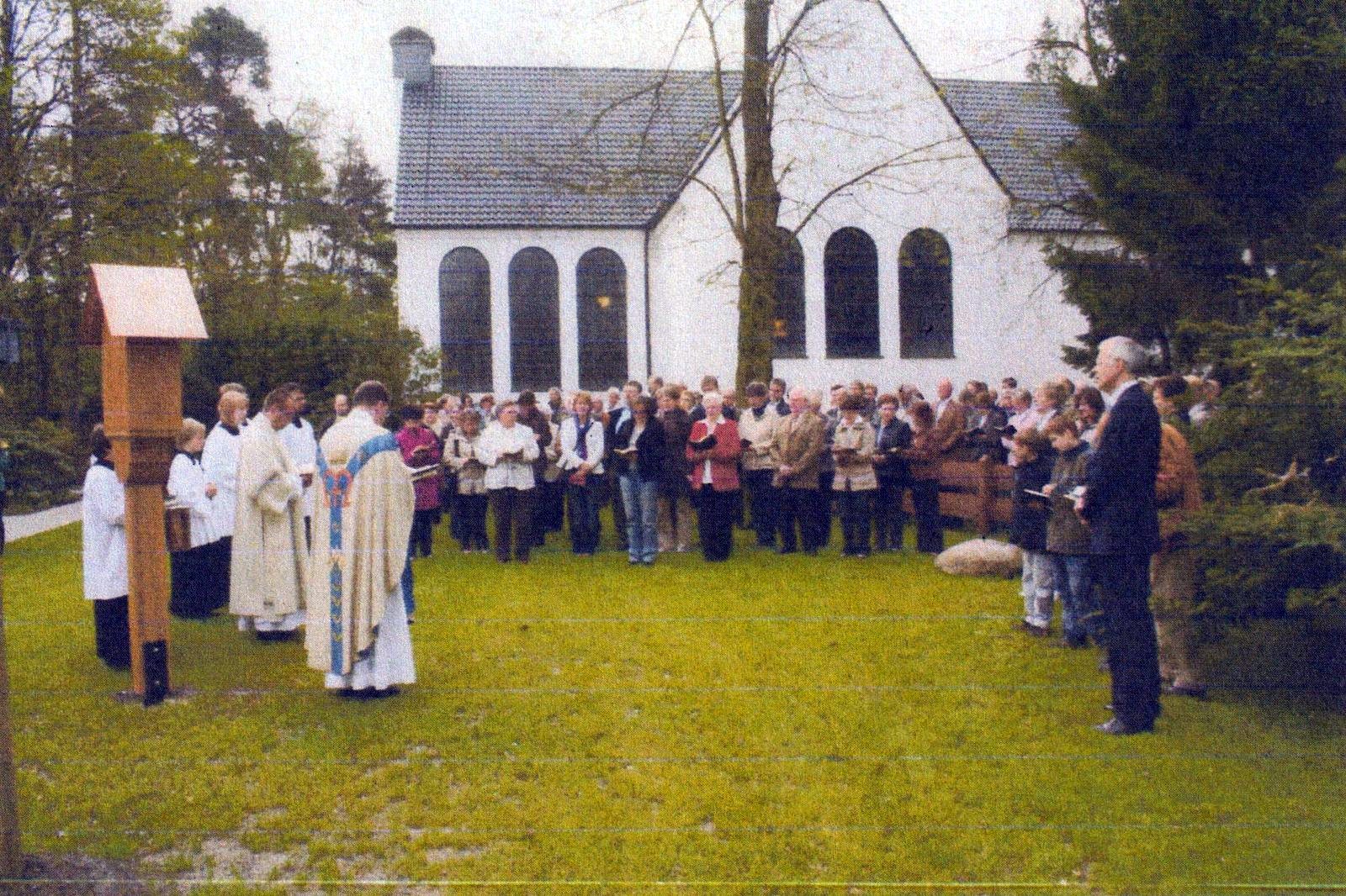 Große Besucherschar auf der Wiese neben dem Bildstock, im Hintergrund ein Kirchengebäude